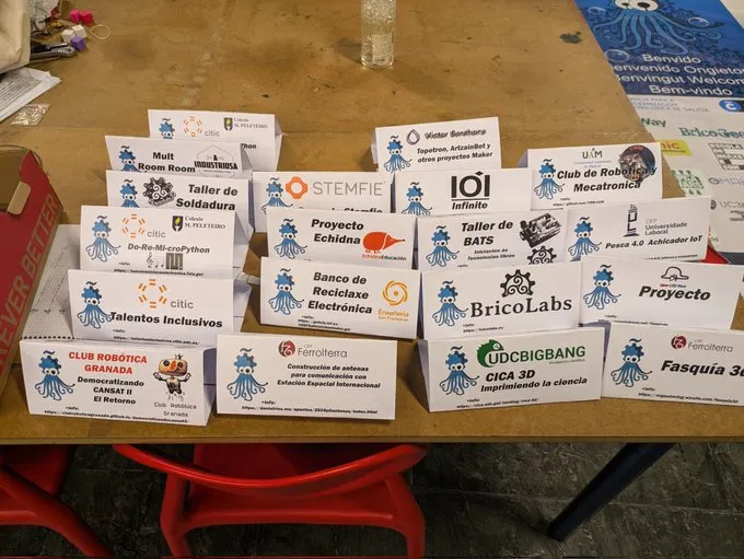 Mesa con los carteles de los proyectos participantes en la OSHWDem, entre ellos el de Echidna.