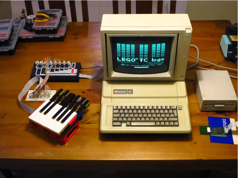 El piano de LEGO conectado a la interfaz de LEGO TC Logo y a un Apple IIe, con la pantalla de inicio de LEGO TC Logo.